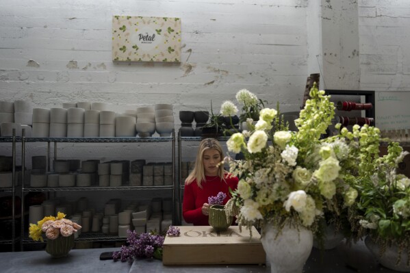 The Renata Ortega Florator, who lost her house and studio in The Eaton Fire, works on a floral arrangement in her temporary studio in Los Angeles, Friday, March 28, 2025 (AP Photo/Jae C. Hong)